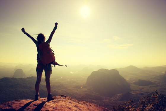 Woman celebrating reaching a mountain summit